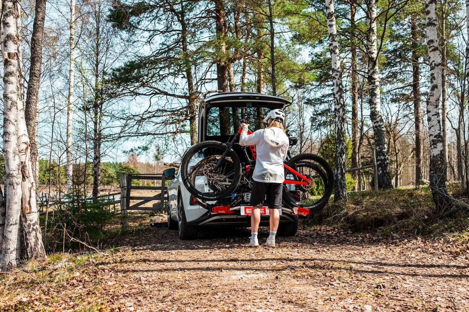 Cykelhållare på bil som parkerats i skogen.