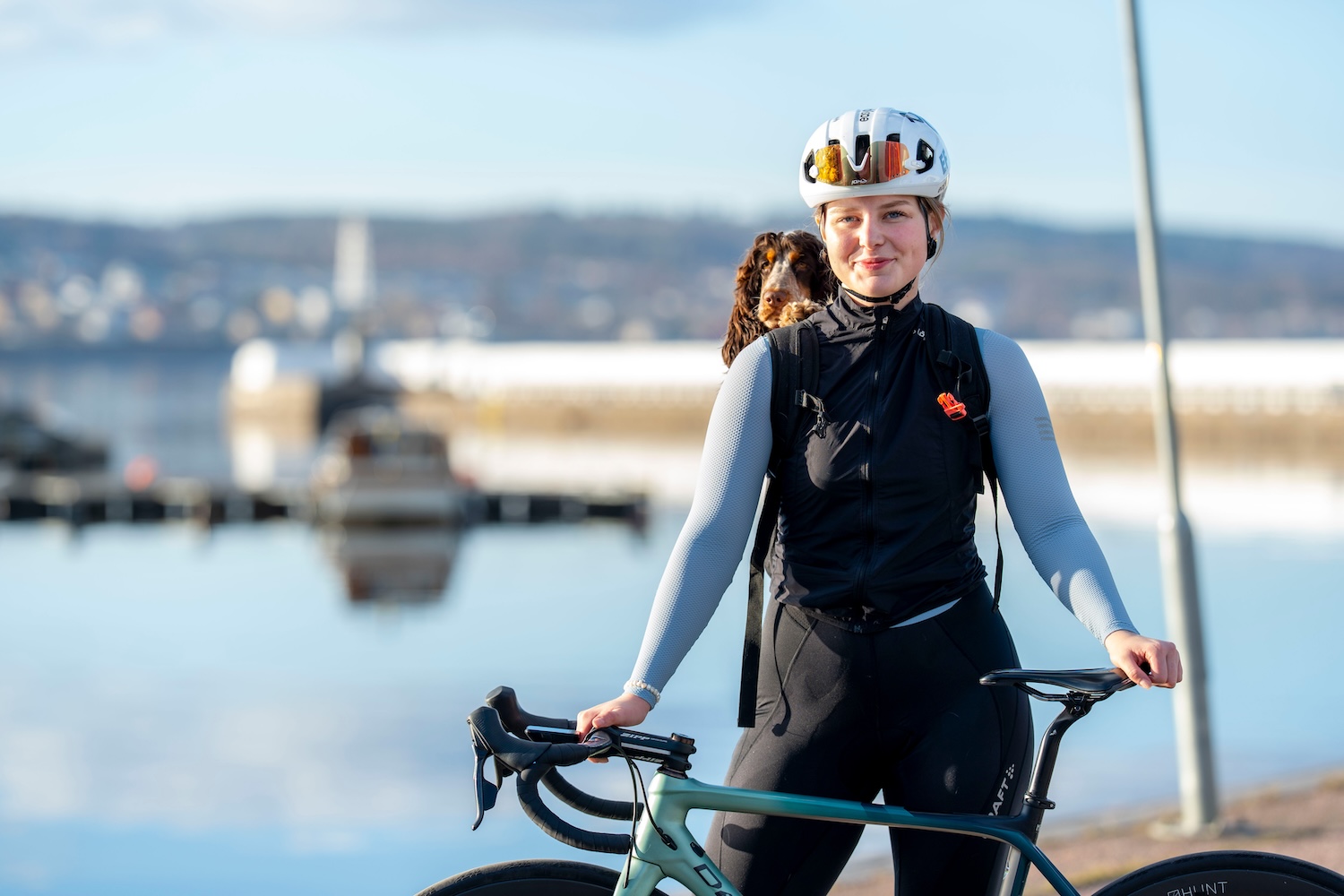 Tuva Kjellsom med hund på ryggen vid sin cykel.
