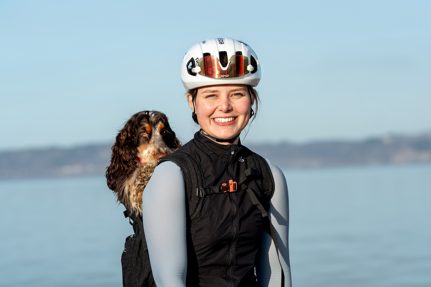 Tuva Kjellson med hund i cykelhjälm.
